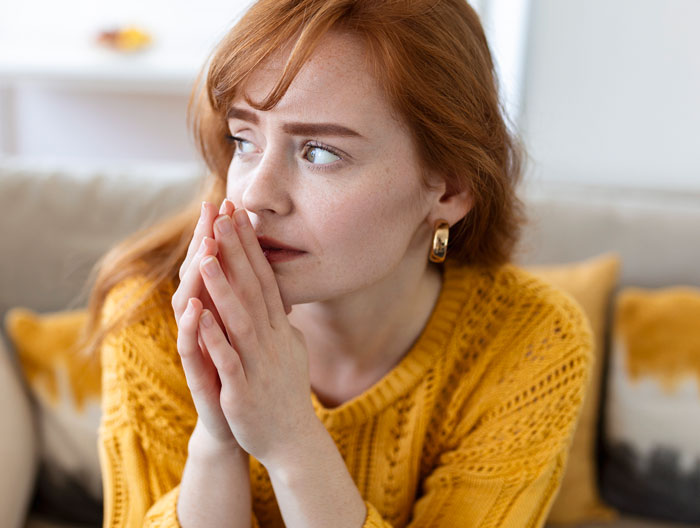Young woman in yellow sweater looking worried and deep in regret after man ditched fianc&eacute;e to chase lost love.