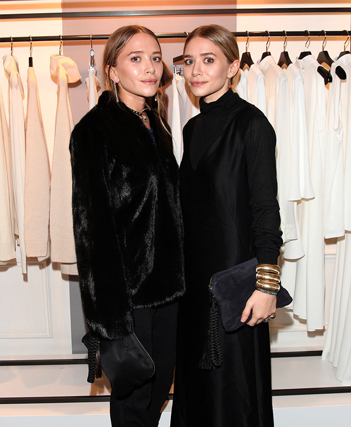 Mary-Kate and Ashley Olsen posing together at a fashion event highlighting Olsen twins disappearance and rift.