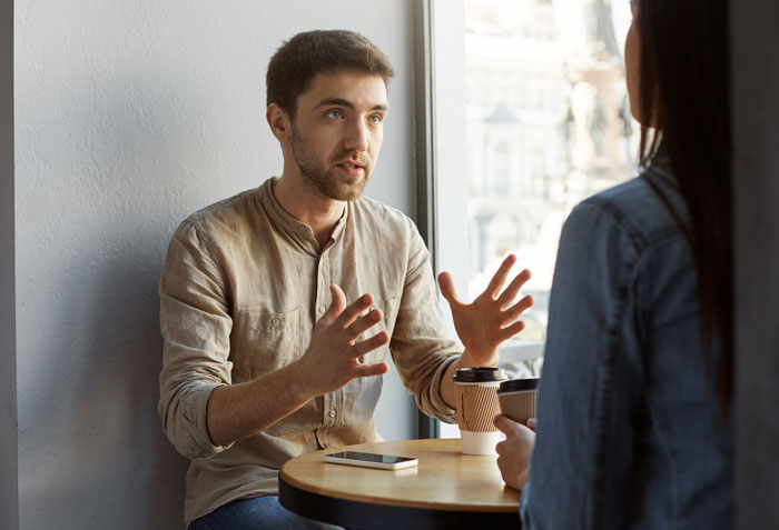 Man and woman having a deep conversation over coffee, illustrating weird and adorable relationship lessons about men.