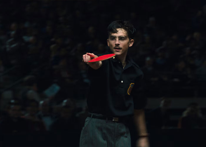 Timoth&eacute;e Chalamet in dark outfit playing table tennis, highlighting Academy insider claims on his Oscar chances.