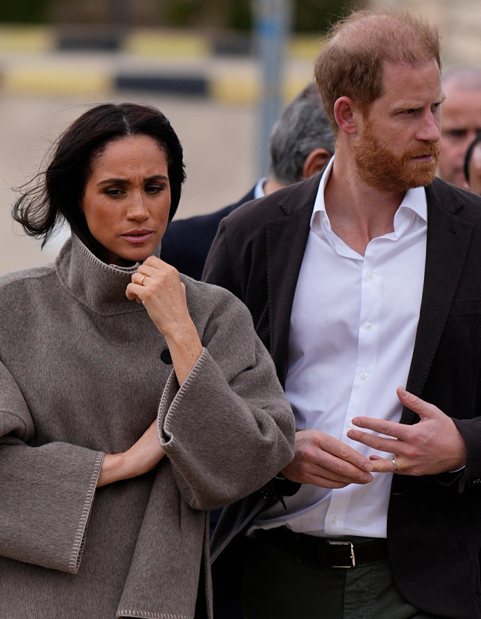 Harry and Meghan outside, looking serious and concerned during public appearance amid furious statement news.