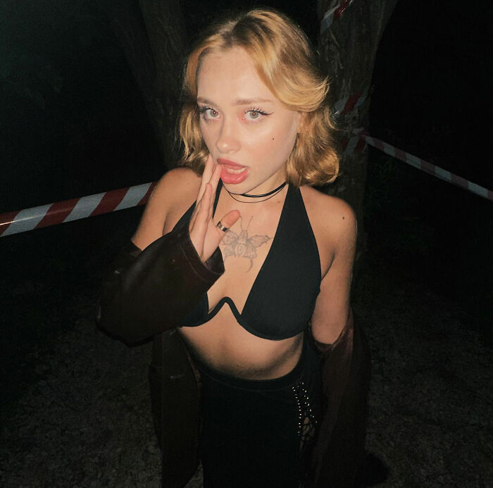 Model posing at night near a taped roadside area in Dubai, showing confidence after horrific injuries and revealing her comeback.