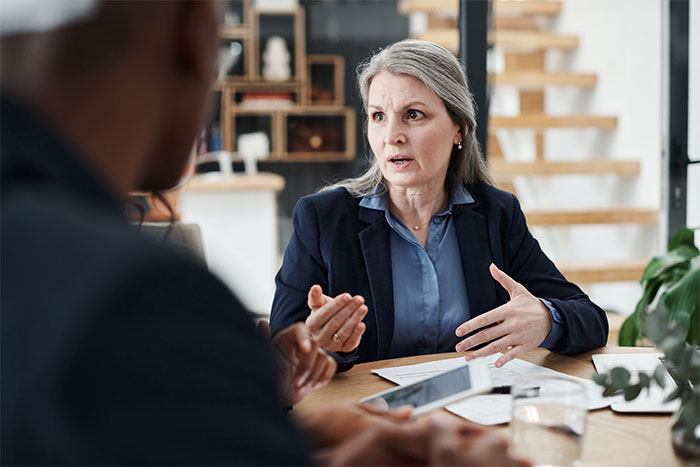 HR professional looking surprised and frustrated during a discussion about employee refusing to train a new hire for free. HR professional looking surprised and frustrated during a discussion about employee refusing to train a new hire for free.