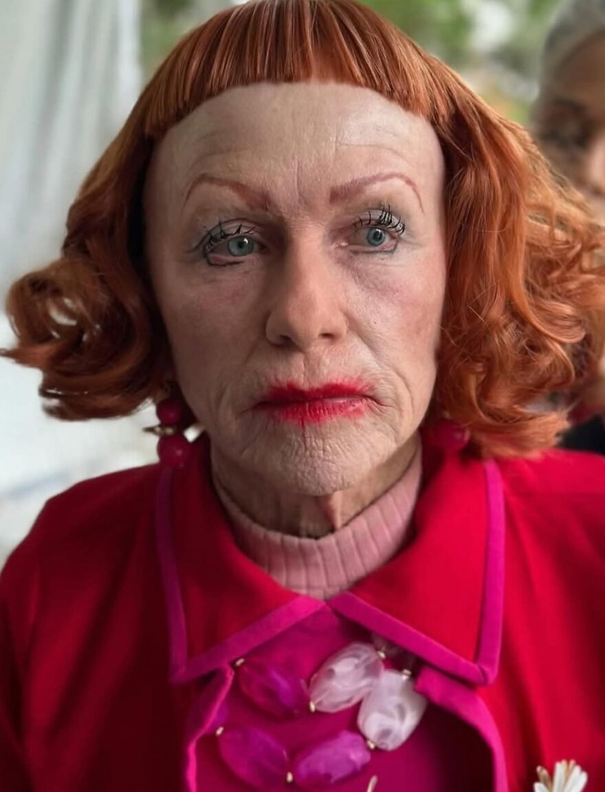 Older woman with bold makeup and red hair in colorful outfit representing supporting performances that stole the show