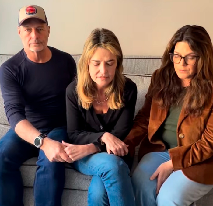 Three people sitting on a couch holding hands, appearing emotional while discussing the Nancy Guthrie case near Phoenix canal.