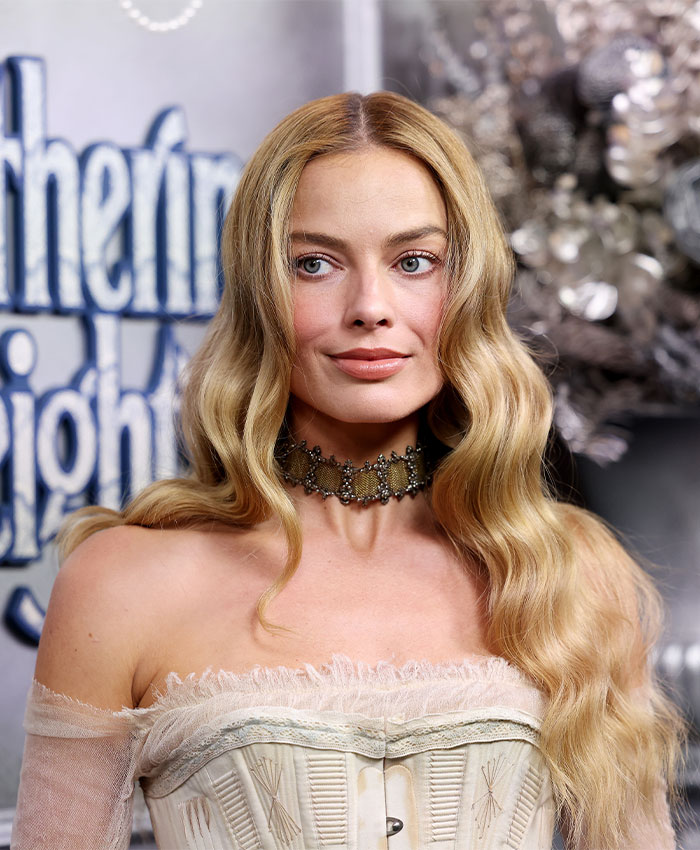 Margot Robbie at Paris Fashion Week wearing an elegant vintage-inspired corset and ornate choker necklace.