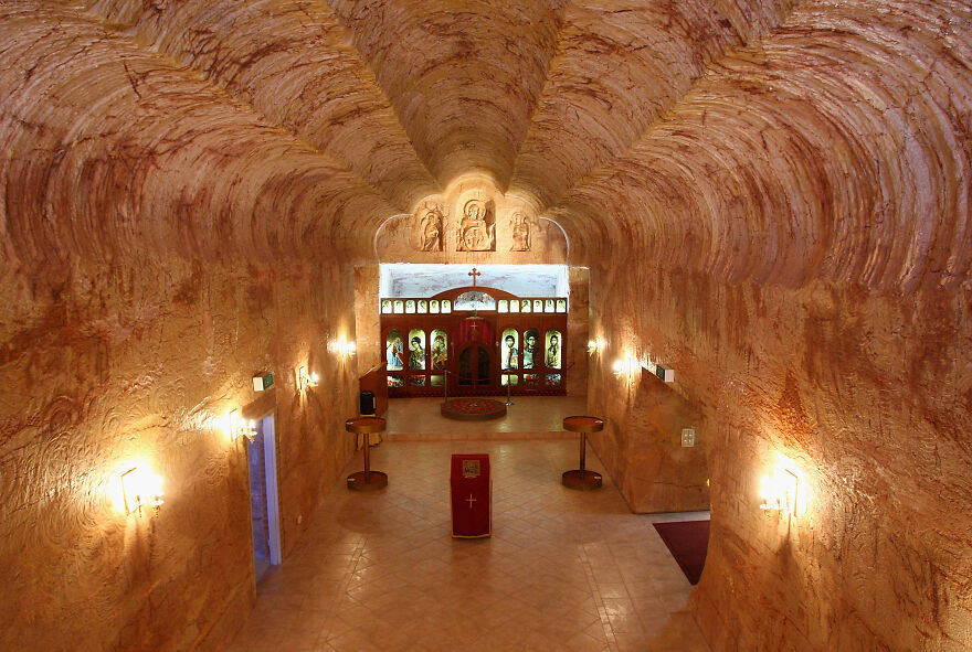 Underground cities with carved stone walls and religious icons illuminated by soft lighting in a historic subterranean space
