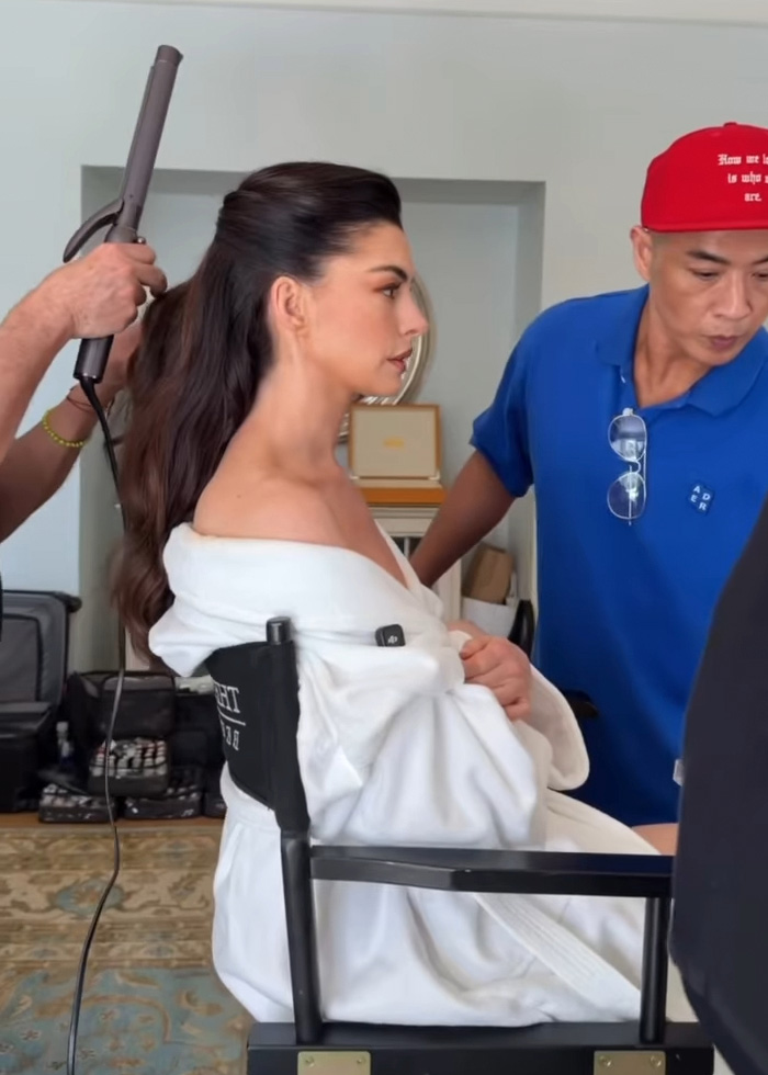 Anne Hathaway penteando o cabelo nos bastidores, revelando o truque por trás de seu rosto tenso após o exame minucioso do Oscar.