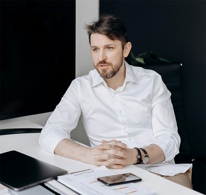 Man with folded hands sitting at desk looking thoughtful, illustrating HR dumbfounded over employee refusing free training. Man with folded hands sitting at desk looking thoughtful, illustrating HR dumbfounded over employee refusing free training.