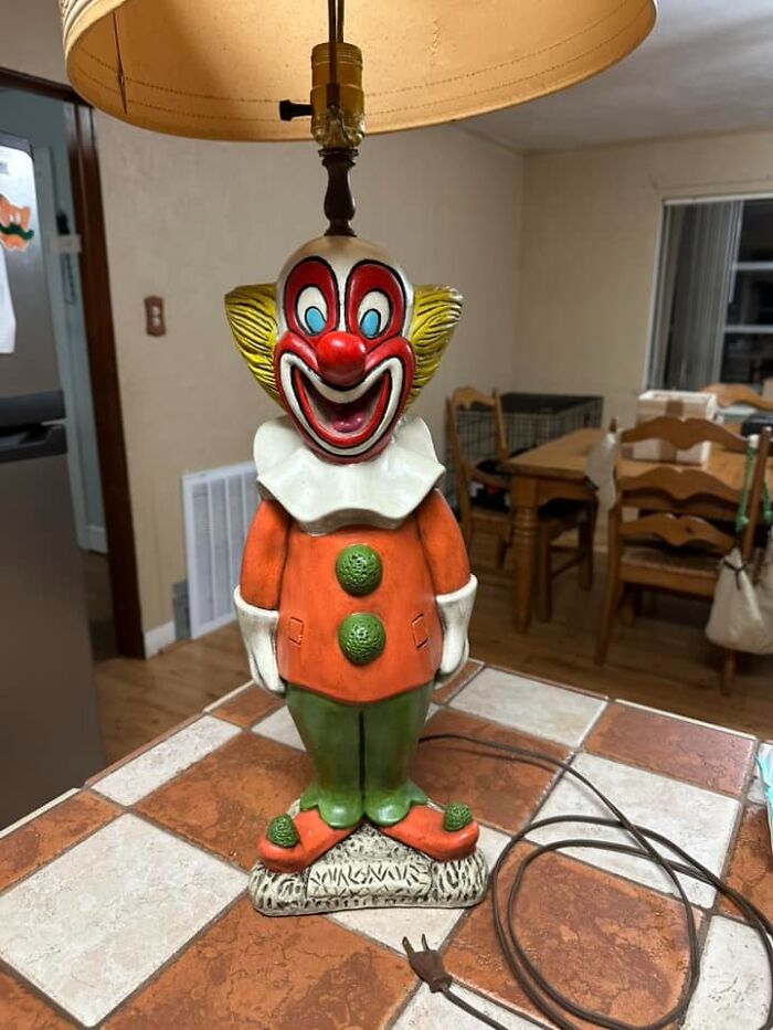 Vintage creepy clown lamp found in an old home, adding bizarre and eerie atmosphere to the room.