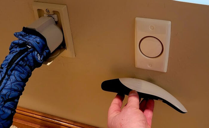 Hand holding unidentified object near wall outlet and device, illustrating internet solving mystery of unidentified objects.