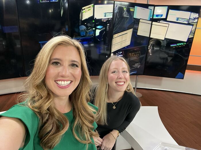 Two smiling women in a tech workspace surrounded by monitors, representing ladies who chose power tools and lab coats.