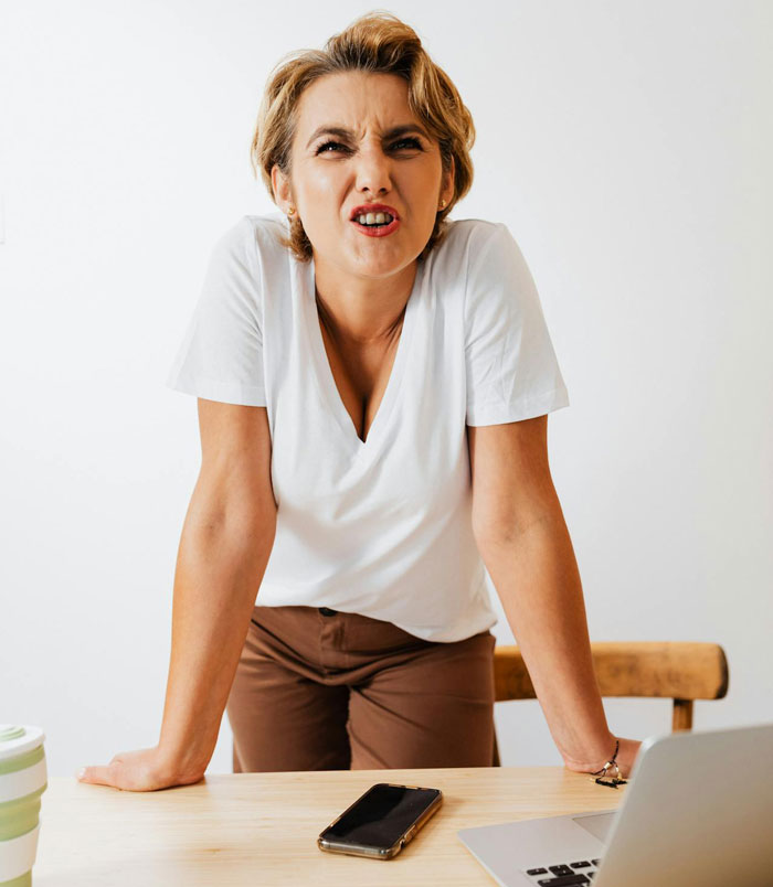 Woman leaning on table looking frustrated, suspecting husband is a psychopath after receiving horrifying texts. Woman leaning on table looking frustrated, suspecting husband is a psychopath after receiving horrifying texts.
