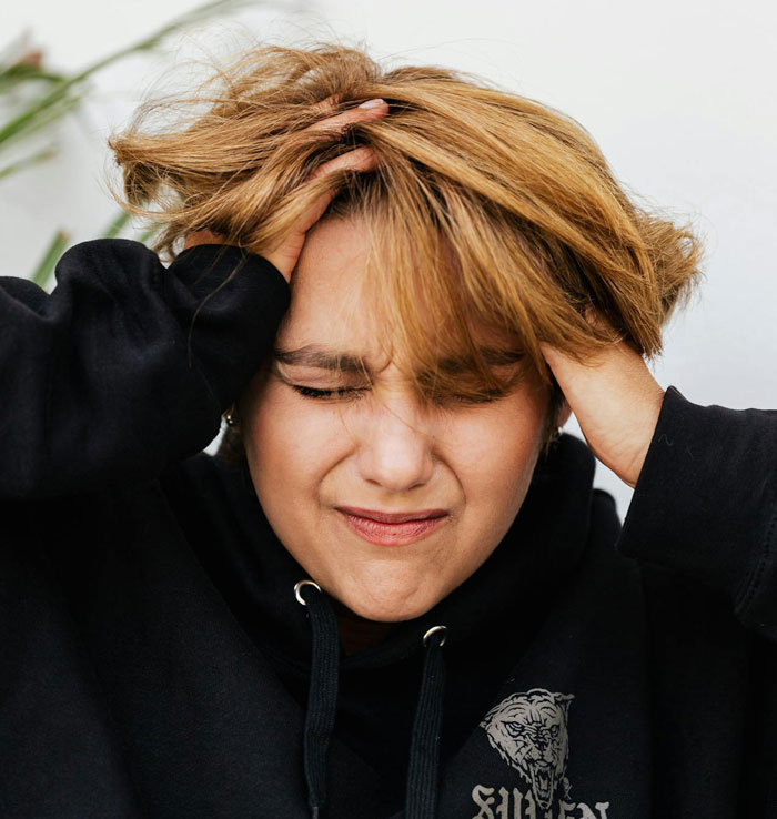 Stressed woman holding her head, showing signs of distress and suspicion related to psychopath behavior and horrifying texts. Stressed woman holding her head, showing signs of distress and suspicion related to psychopath behavior and horrifying texts.