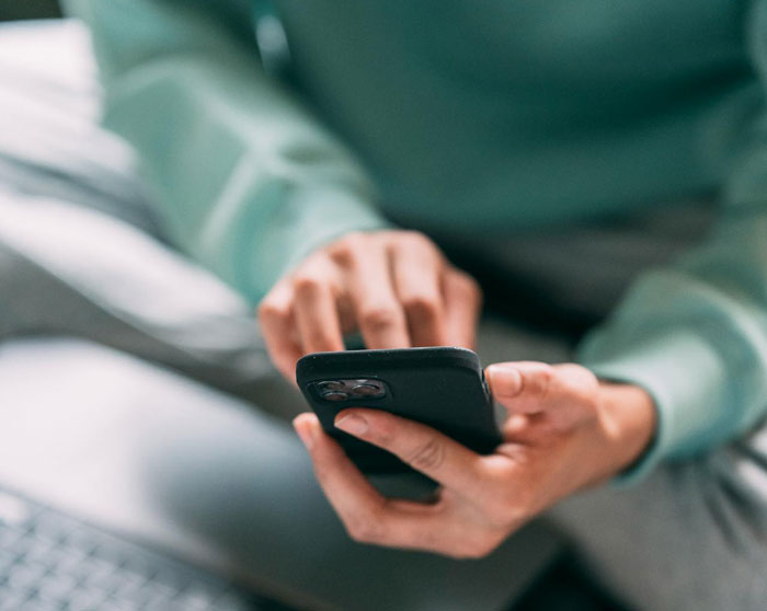 Close-up of woman’s hands holding a phone, suspecting husband is a psychopath from disturbing text messages. Close-up of woman’s hands holding a phone, suspecting husband is a psychopath from disturbing text messages.