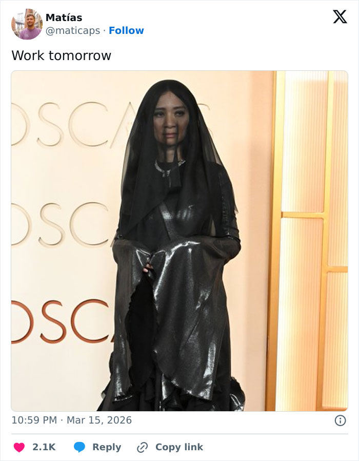 Woman dressed in black metallic outfit and veil posing in front of Oscars backdrop, capturing Oscars memes and viewer reactions.