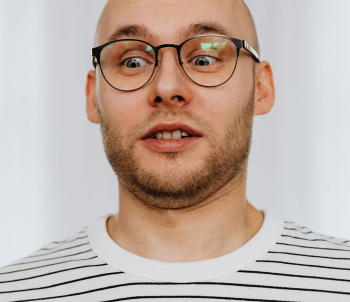 Man with glasses and striped shirt looking surprised, relating to woman suspecting husband is a psychopath. Man with glasses and striped shirt looking surprised, relating to woman suspecting husband is a psychopath.