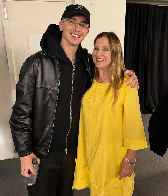 Timoth&eacute;e Chalamet smiling with a woman in a yellow dress, sparking wild theories about his date at the Actor Awards.