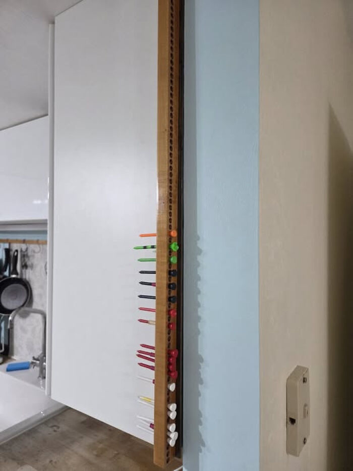 Wooden board with various colored push pins mounted on the wall, an example of solving unidentified objects mystery online.