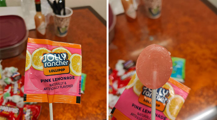 Pink Lemonade Jolly Rancher lollipop with obvious shrinkflation compared to original size on a kitchen table.