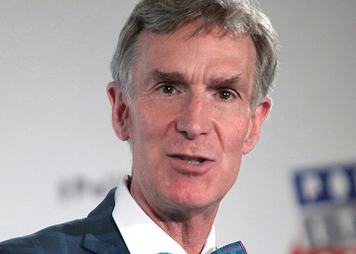 Middle-aged man in a suit speaking at an event, illustrating moments when people met celebrities who turned out to be jerks.