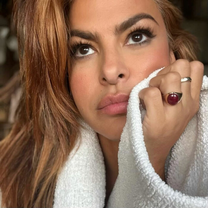 Close-up of a woman with styled hair and makeup, highlighting plastic surgeons’ views on Eva Mendes new looks.