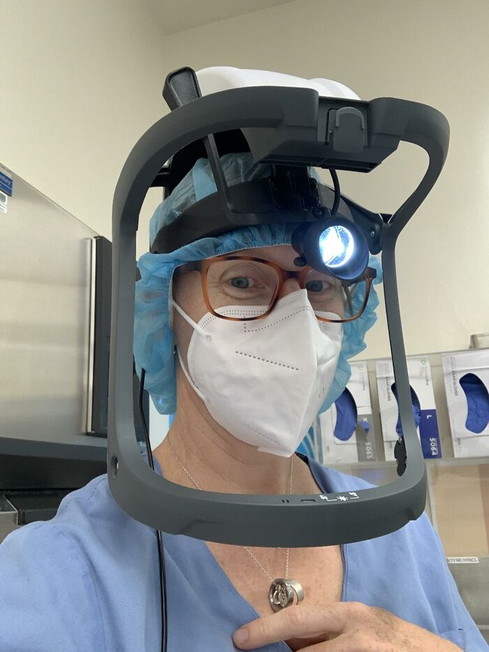 Female scientist wearing lab coat and mask, using medical headlamp, representing women choosing power tools and lab coats.
