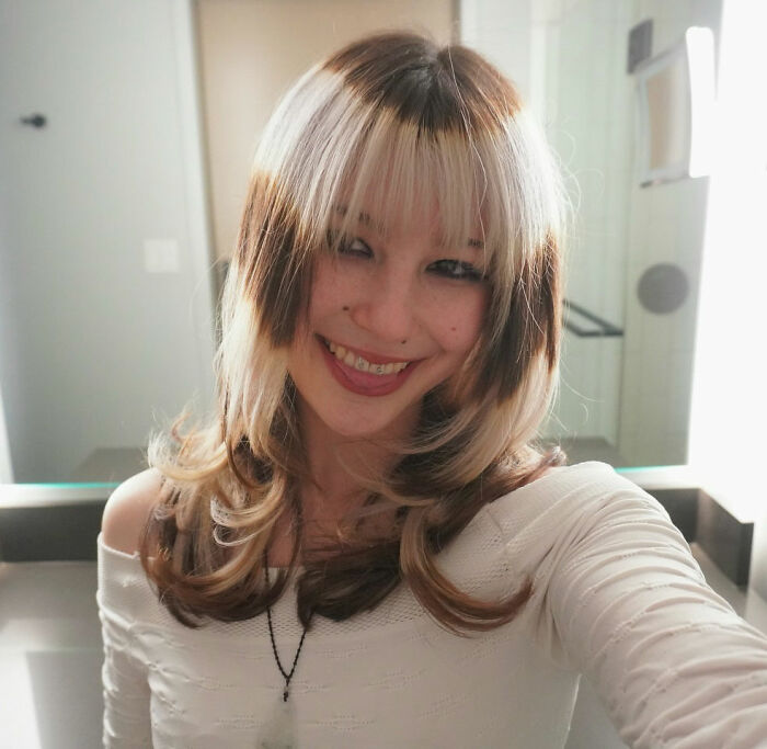 Young woman with blonde and brown hair smiling indoors, related to US Olympic hero Alysa Liu dropping out of World Championships.