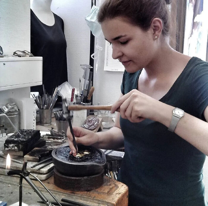 Woman working with power tools and lab equipment in a workshop, showcasing skilled craftsmanship and focus.