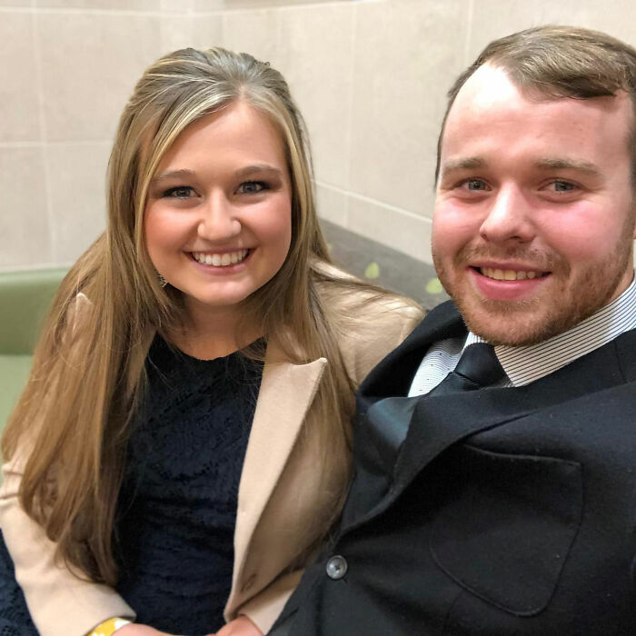 A smiling young couple sitting close together, highlighting Michelle Duggar's heated confrontation after bailing daughter-in-law out of jail.