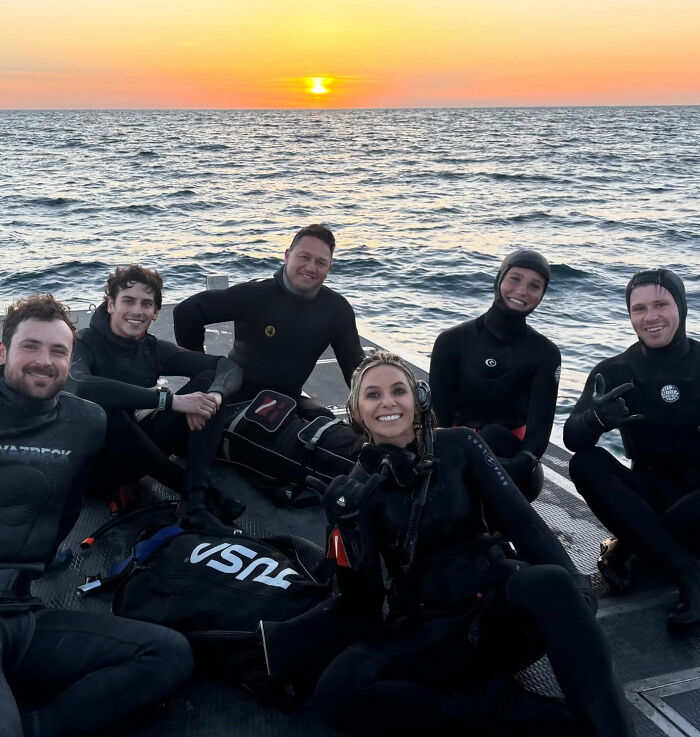 Robert Irwin e amigos em roupas de neoprene em um barco ao pôr do sol, relataram rumores de reações de novas namoradas.