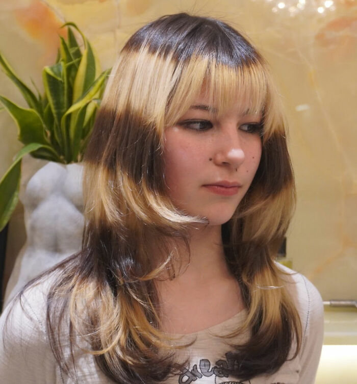 Alysa Liu with styled hair, posing indoors near a plant, representing Olympic figure skating and retirement news.