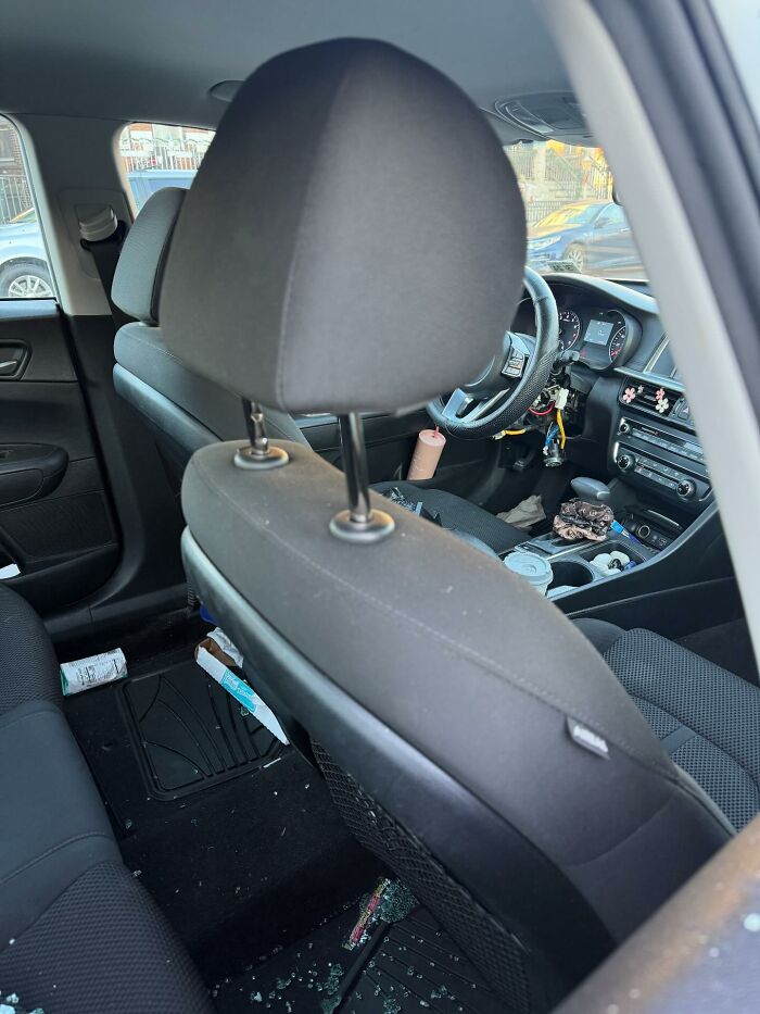 Car interior showing broken glass on the floor and a messy front seat, illustrating one-in-a-million stories people lived through.