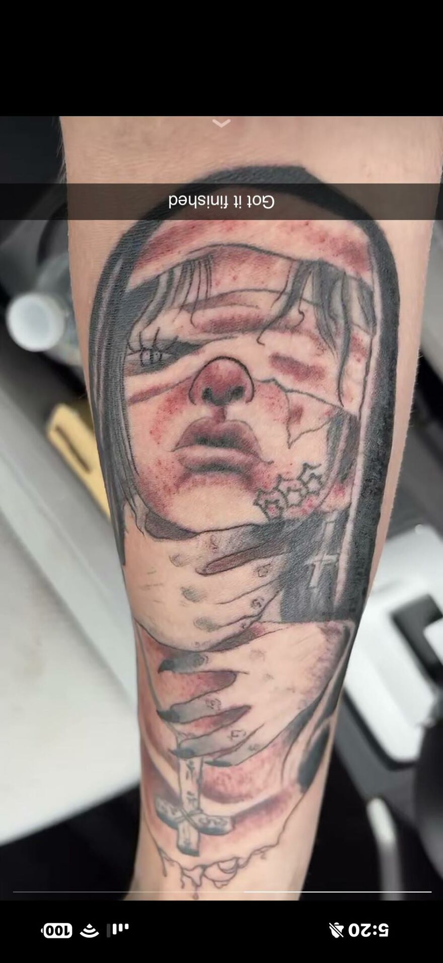 Tattoo of a distressed face wrapped in hands with a cross, showcasing one of the 83 tattoos that question the artists and wearers.