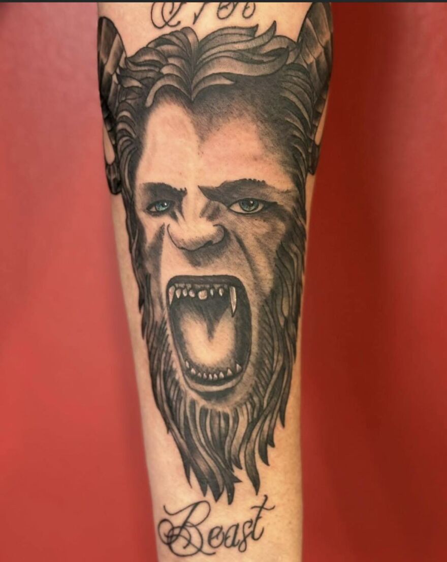 Tattoo of a beast with fangs on forearm, showcasing a unique and bold design from a questionable tattoo collection.