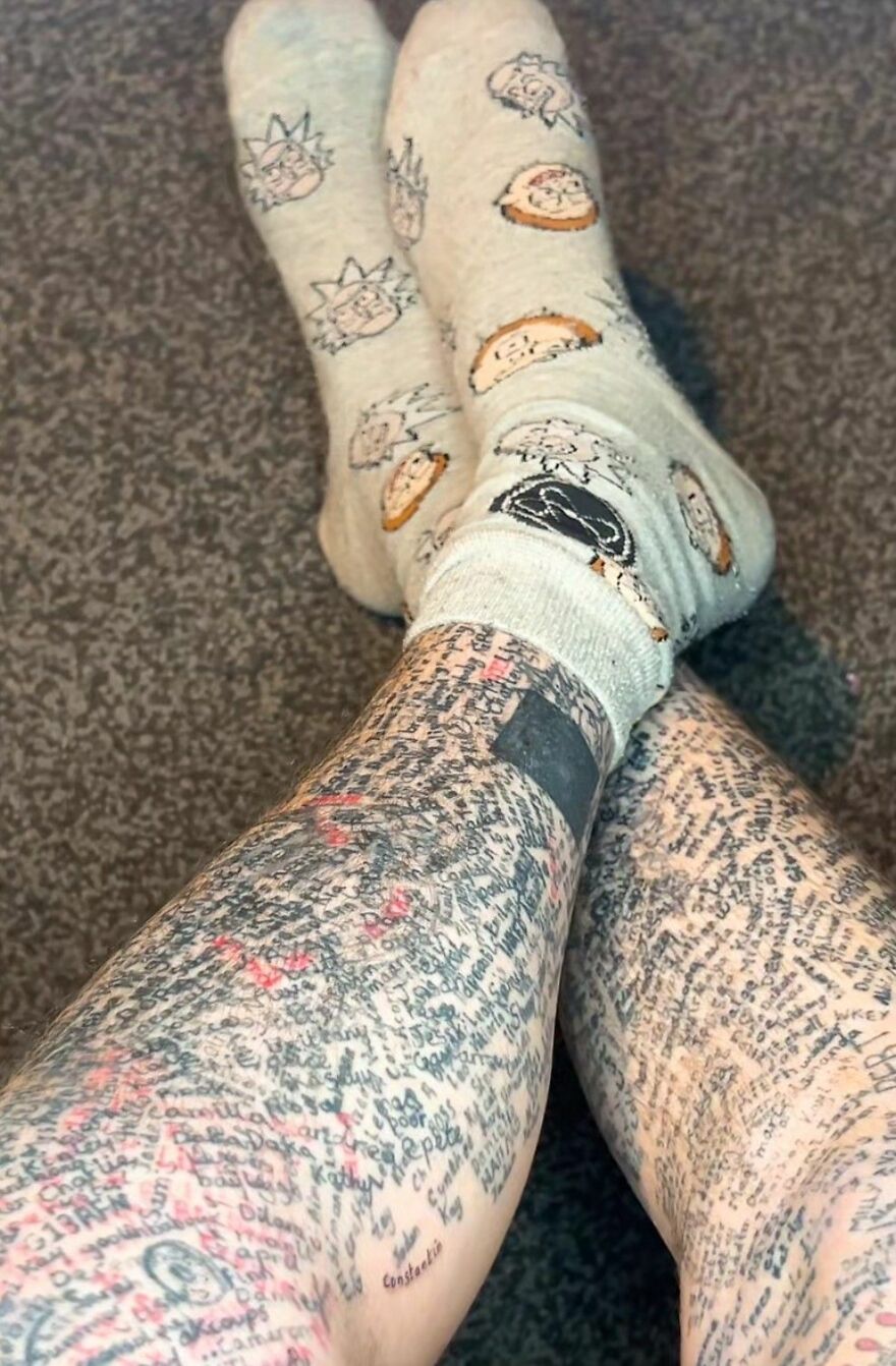 Legs covered in dense text tattoos with cartoon-themed socks, showcasing unusual and intricate tattoo designs.