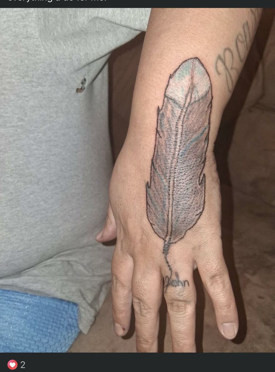 Tattoo of a large feather covering the back of a hand, showing unusual design and questionable tattoo art quality.