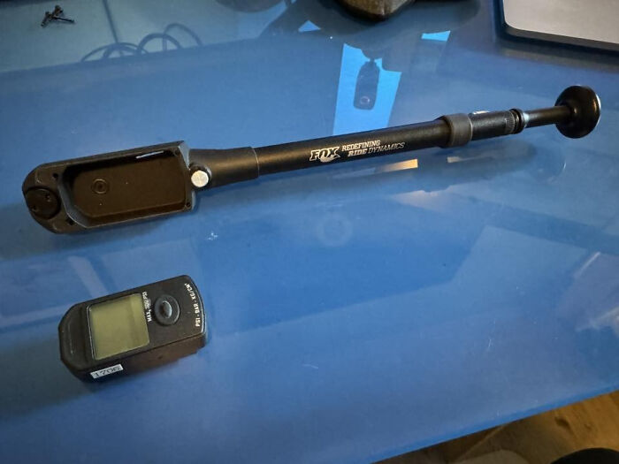 Bicycle shock pump and digital pressure gauge on blue surface, an example of solved unidentified objects online.