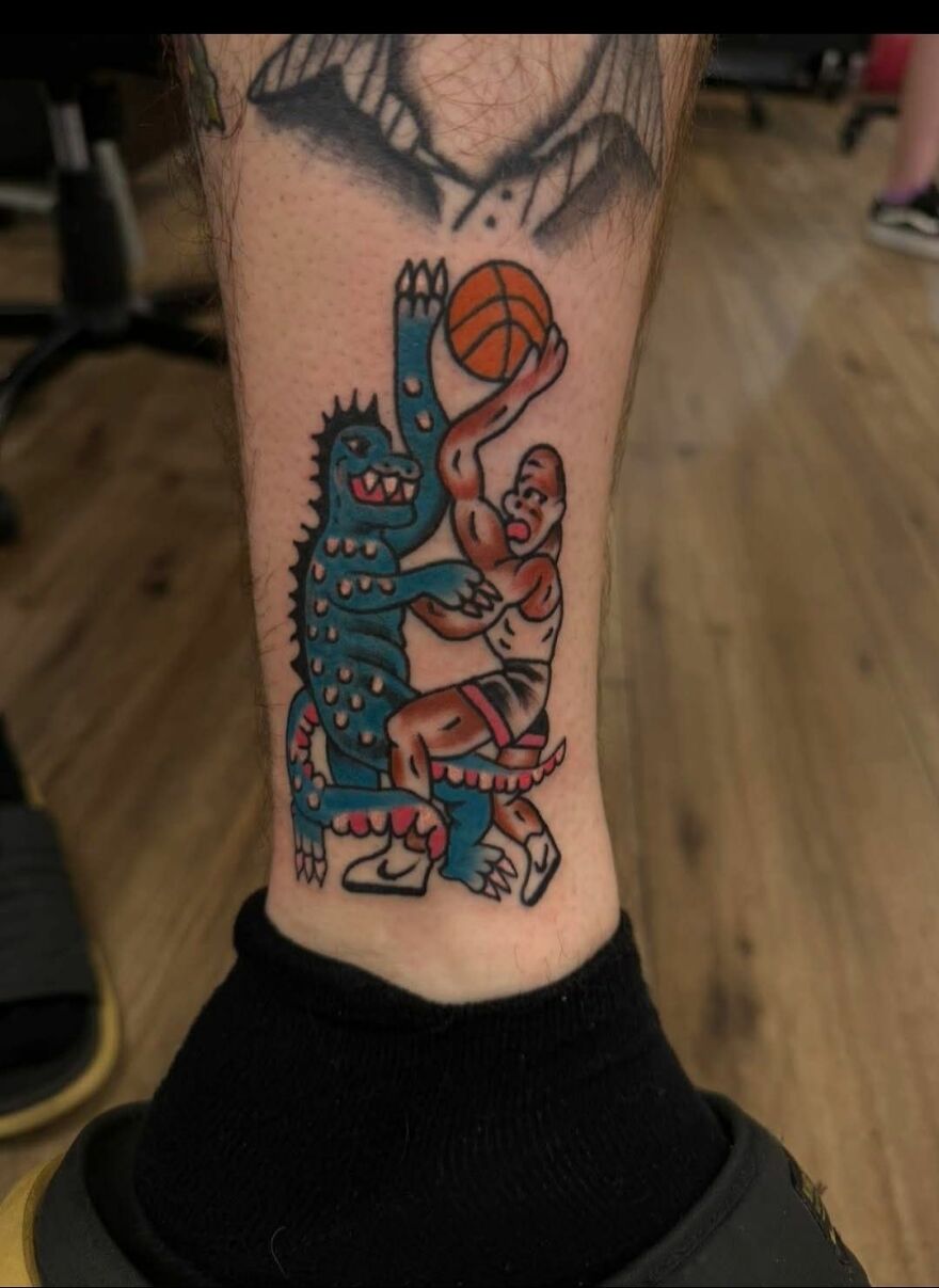 Colorful tattoo of a basketball player guarded by a blue monster, showcasing unusual tattoos that make you question the art and artists.
