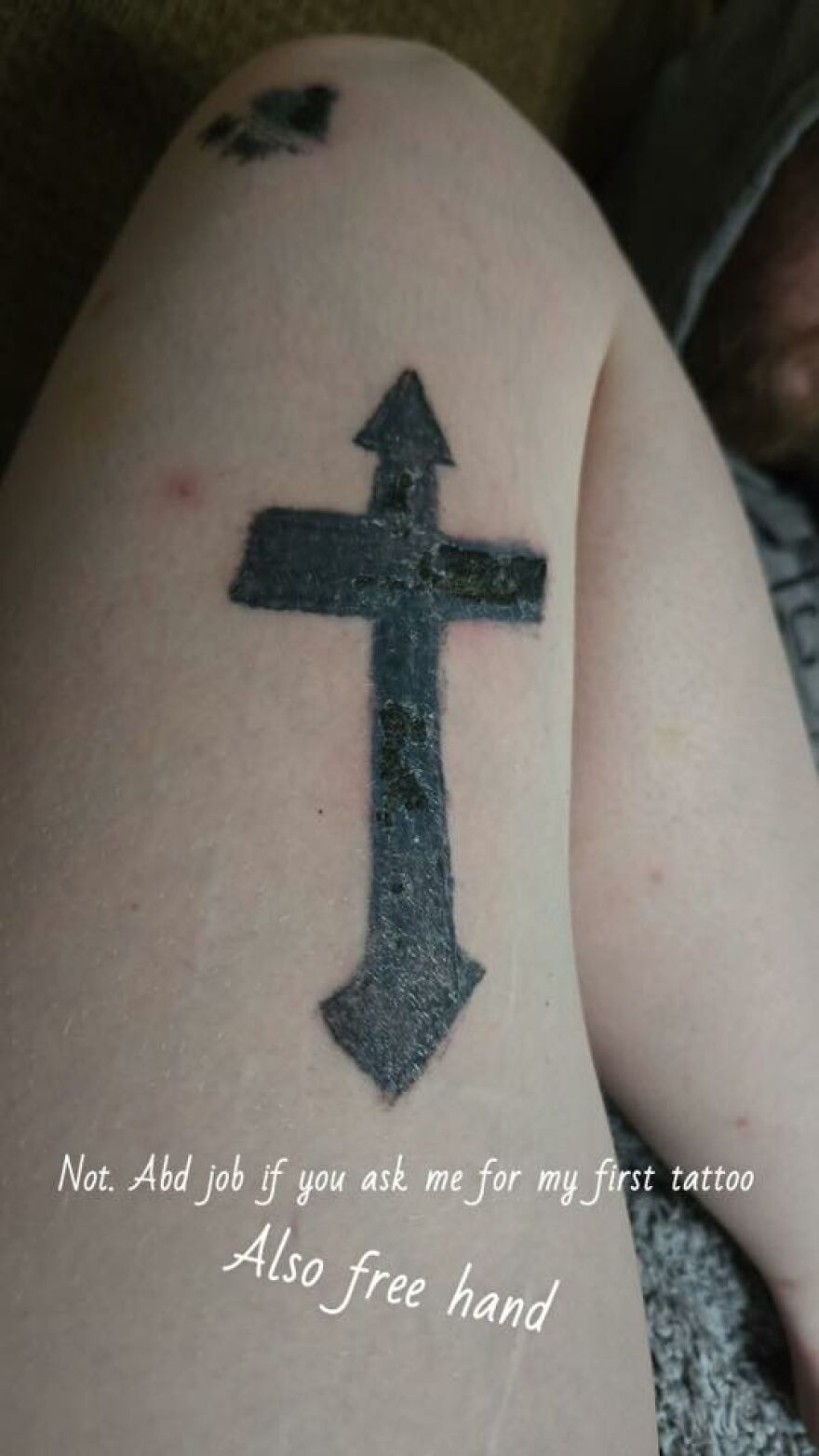 Tattoo of a black cross with arrows on arms, showing questionable tattoo art and design on pale skin.