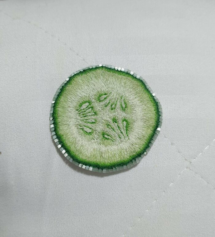 A close-up of a stunning embroidery creation of a cucumber slice, inspiring an embroidery hobby.