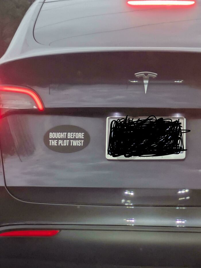 Black Tesla with a hilarious and unhinged bumper sticker that reads bought before the plot twist on the back.
