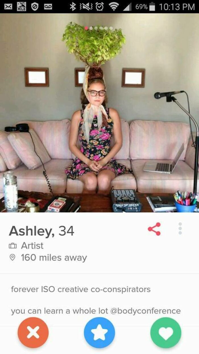 Woman with plant on head sits on couch in a creative Tinder profile making people laugh and cringe about dating life.