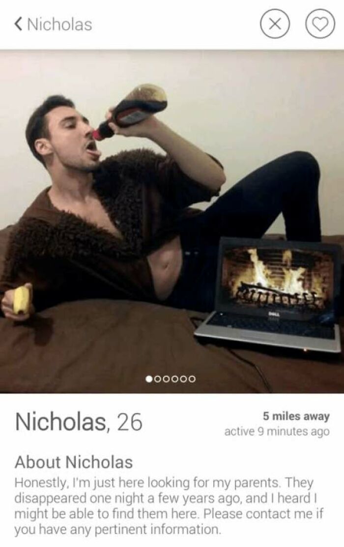 Tinder profile of Nicholas, 26, humorously seeking parents, posing with a bottle and laptop showing a fireplace scene.