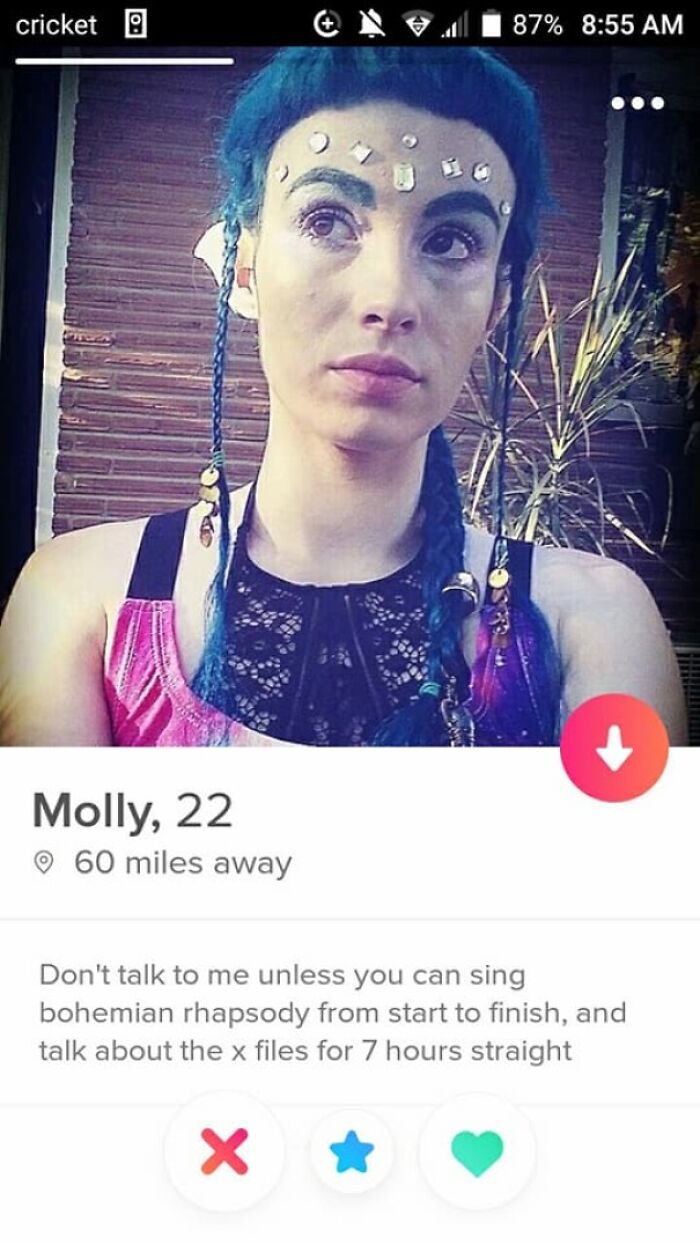 Tinder profile of Molly, 22, with blue braided hair and face jewels, featuring a humorous and quirky bio about singing and The X Files.