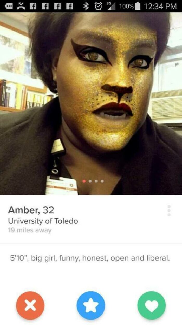 Tinder profile of Amber, 32, using a lion face filter with funny and honest dating bio traits visible.