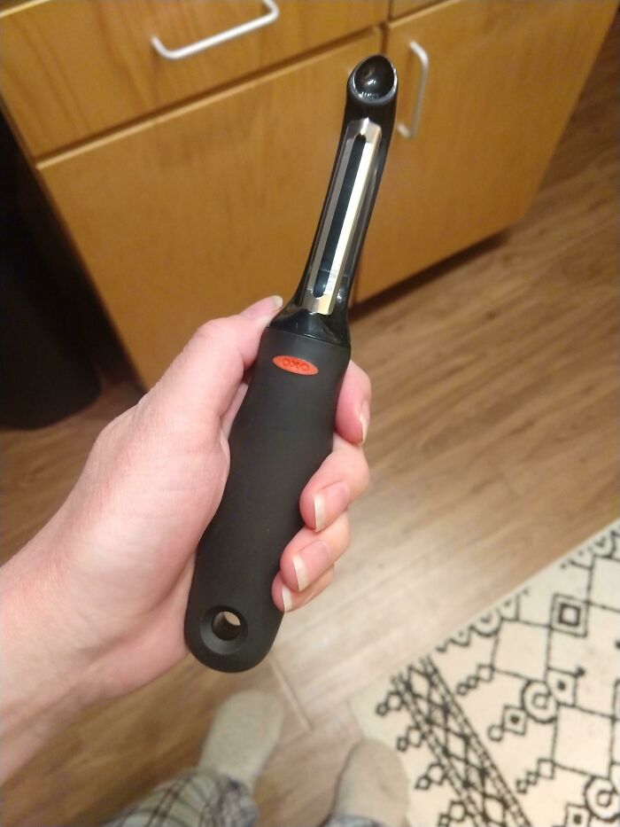 Hand holding a black-handled vegetable peeler illustrating an interesting rabbit hole discovery at home.