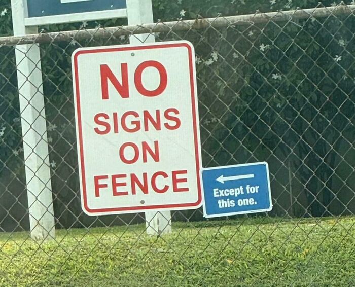 Sarcastic image showing a no signs on fence warning with a smaller sign humorously allowing that sign only.