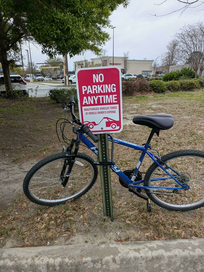 A blue bike locked to a no parking sign, illustrating sarcastic images that hit different with ironic humor.