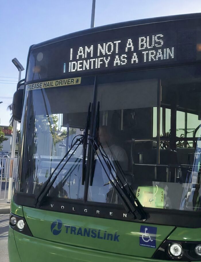 A sarcastic bus sign displaying I am not a bus I identify as a train, highlighting ironic sarcasm in public transport.